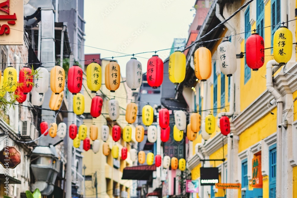 Naklejka premium Chinese lanterns strung across colourful shopfronts in the alleyways of Kwai Chai Hong - Kuala Lumpur, Malaysia