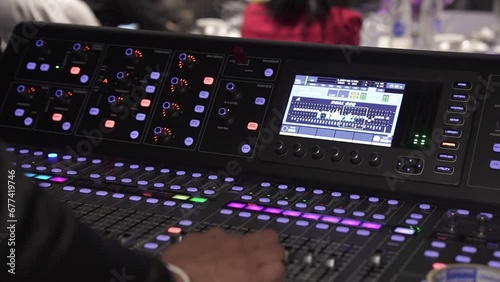 real sound maestro navigates the mixing board at a live event checking audio levels photo
