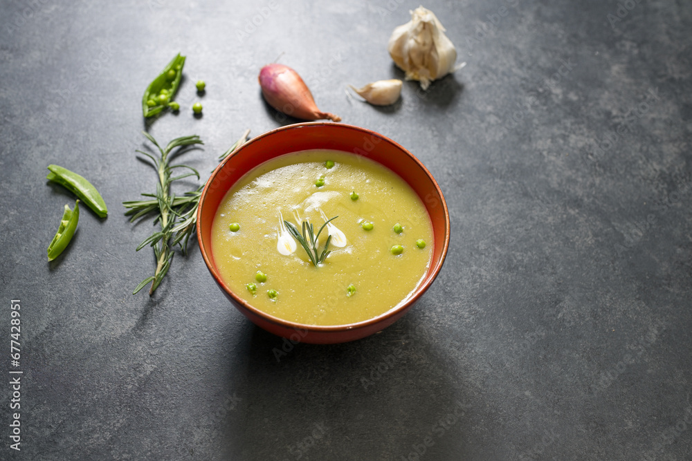 Split pea soup on black table with ingredients around Split pea soup on black table with ingredients around