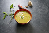 Split pea soup on black table with ingredients around