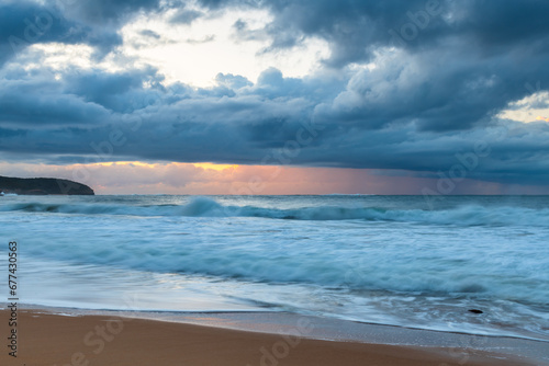 Sunrise seascape with low clouds and waves
