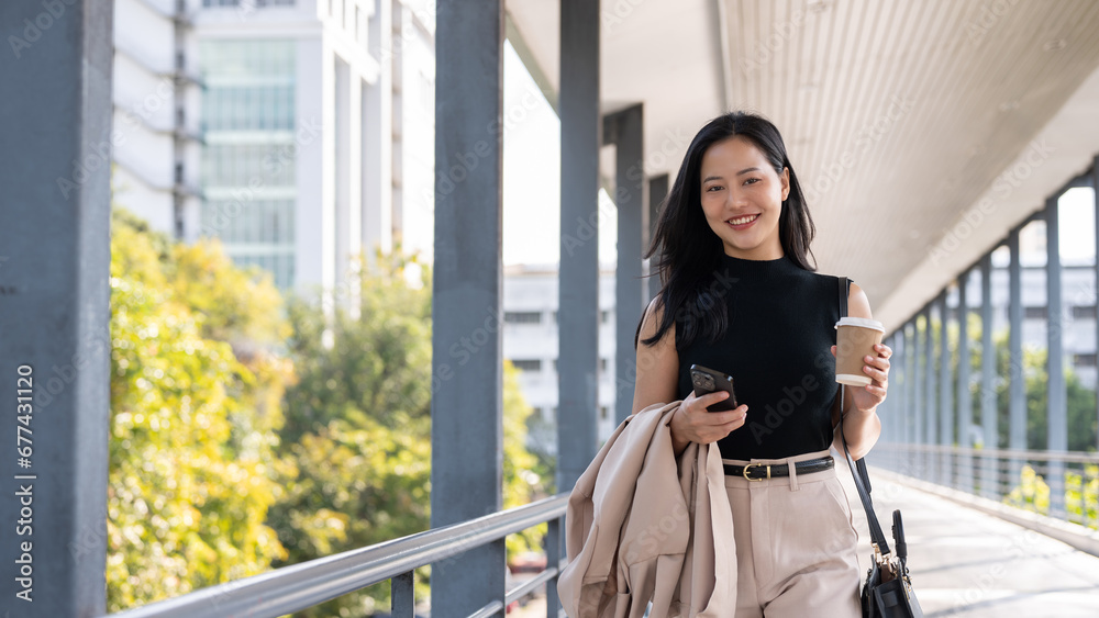 A beautiful Asian businesswoman is walking on a skywalk, going to her office in the morning. A beautiful Asian businesswoman is walking on a skywalk, going to her office in the morning.
