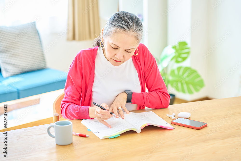 テキストで勉強しているシニア女性 テキストで勉強しているシニア女性