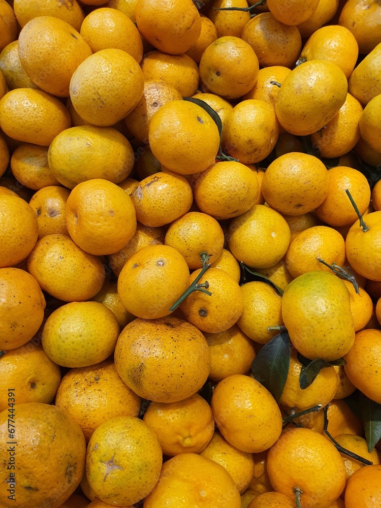 Close up pile of oranges sold at the market as a background.