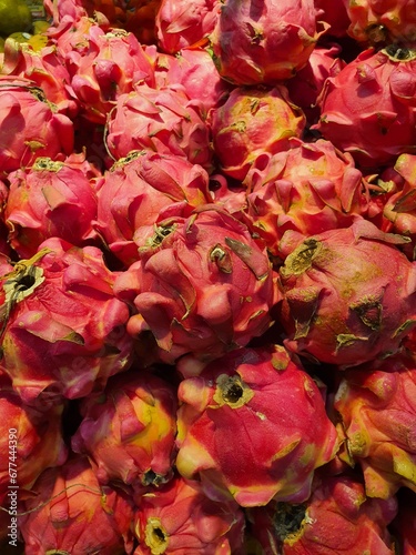 Close up pile of tasty fresh dragon fruit sold at the market as a background.