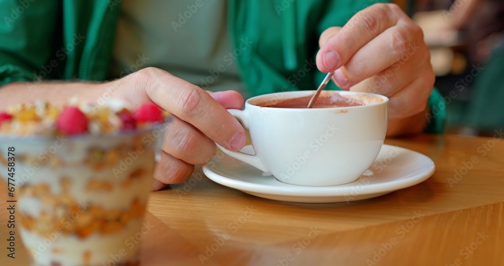 Man drinking hot cocoa sitting in a cafe