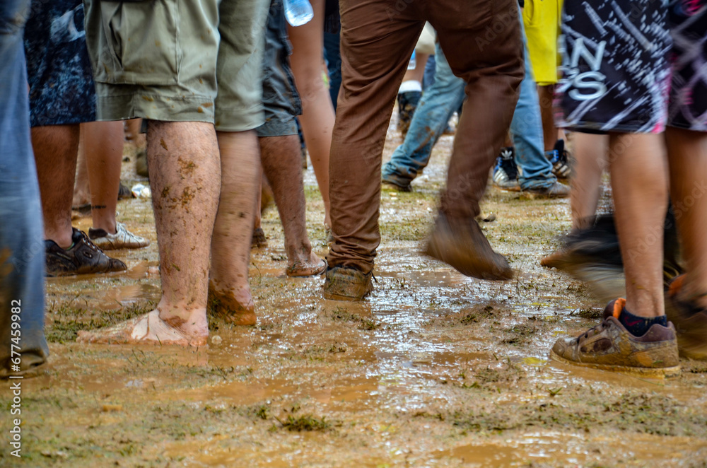 Feet of people dancing on a muddy dance floor