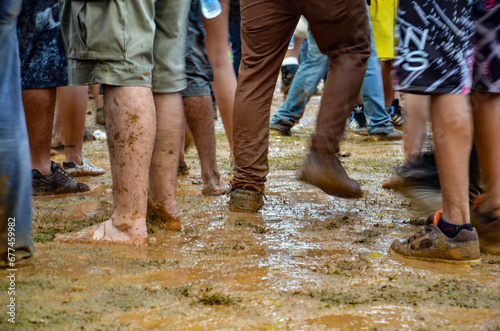 Feet of people dancing on a muddy dance floor © Gabriel Mussi Luz