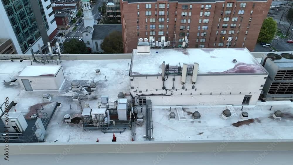 Rooftop view of a skyscraper with HVAC units and cityscape in the background. Aerial truck shot. Rooftop view of a skyscraper with HVAC units and cityscape in the background. Aerial truck shot.