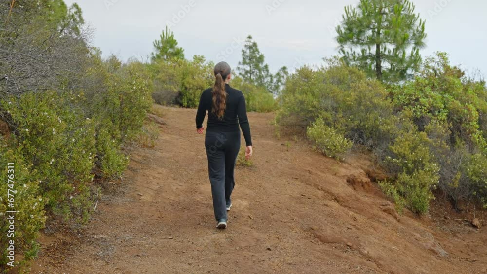 Woman walking in green nature of Tenerife, tourist in black tracksuit Woman walking in green nature of Tenerife, tourist in black tracksuit