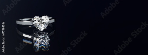 Heart cut diamond ring on black glossy background. Wide image.