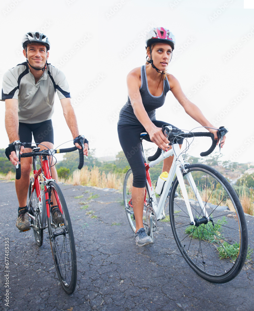 Obraz premium Cycling, couple and road in in nature with fitness, training and travel on bicycle together. Outdoor, people and exercise on bike for fun, workout and path in countryside adventure or mountain