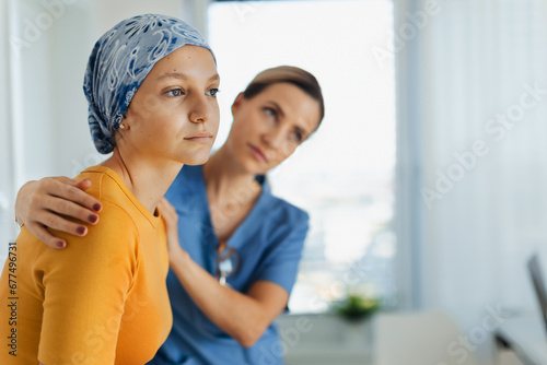 Teenage oncology patient talking with doctor. Oncologist treating teen girl with cancer and provide emotional support, helping her with anxiety and depression. photo