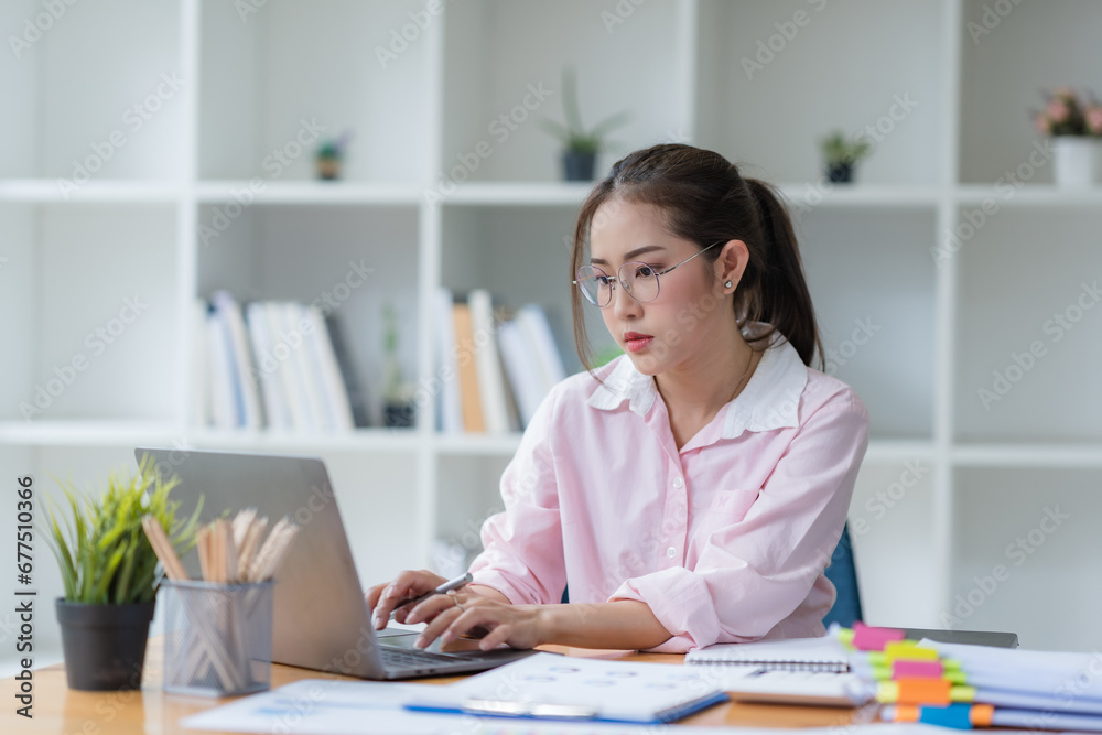 Asian businesswoman smiling using laptop computer at office. Confident Asia businesswoman sitting happily in the office. Asian businesswoman smiling using laptop computer at office. Confident Asia businesswoman sitting happily in the office.