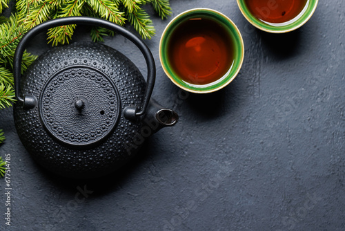 Teapot, cup, and fir tree branches create a cozy scene