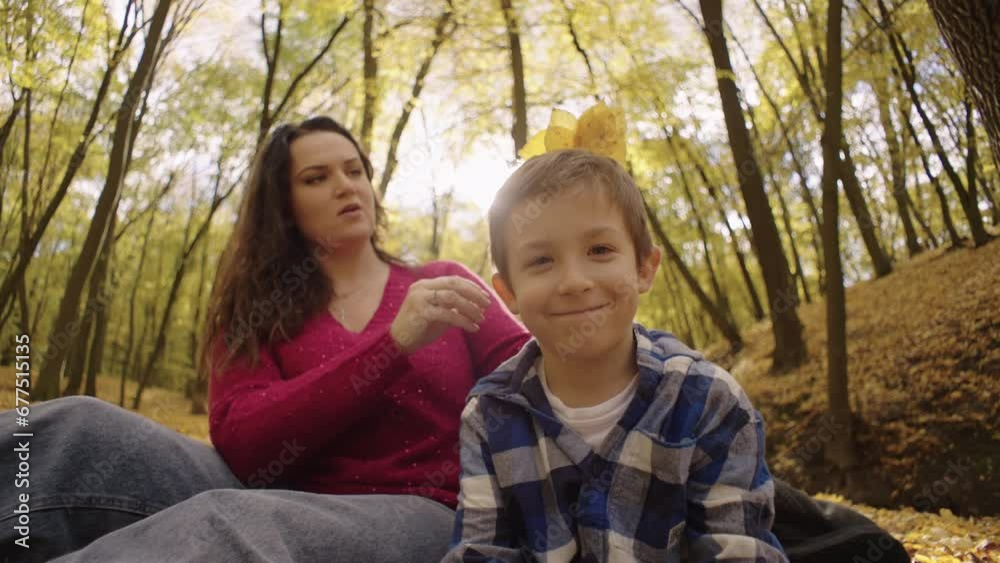 Autumn's Embrace: A Mother's Love Shines Bright as She and Her Son Picnic Amidst Golden Leaves. High quality 4k footage Autumn's Embrace: A Mother's Love Shines Bright as She and Her Son Picnic Amidst Golden Leaves. High quality 4k footage