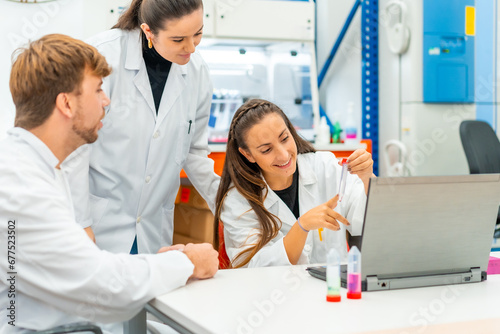 Happy doctor using laptop while analyzing samples in a laboratory