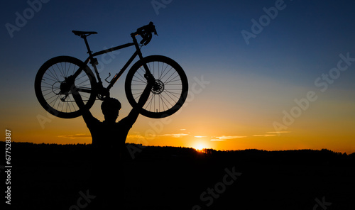 Fototapeta Naklejka Na Ścianę i Meble -  cyclist silhouette with bicycle raised to sky race and victory concept