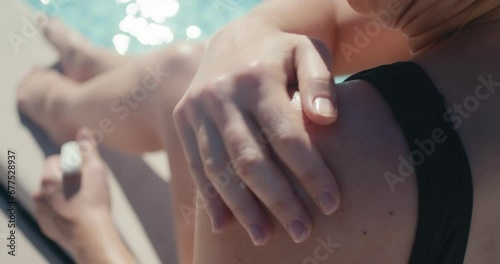Female hand shoulder massages sunscreen tan skin protection close up