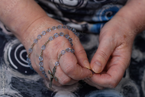 Różaniec owinięty wokół dłoni modlącej się kobiety  photo