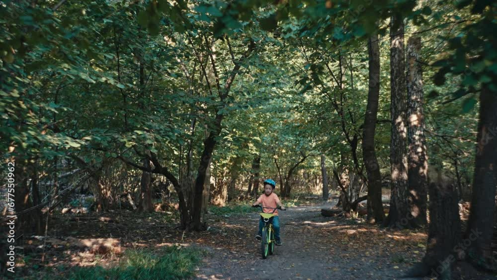 Childhood Joys: Boy in Protective Gear Explores the Park on his Bicycle. High quality 4k footage Childhood Joys: Boy in Protective Gear Explores the Park on his Bicycle. High quality 4k footage