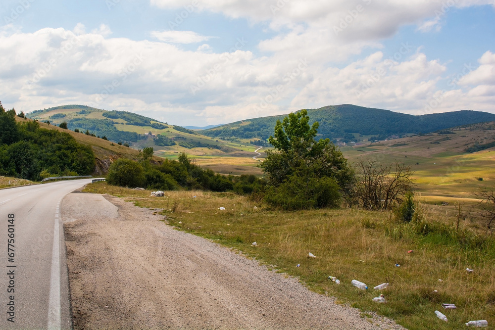 Trash litters the roadside in the summer landscape near Gornje Ratkovo in the Ribnik municipality of Banja Luka region, Republika Srpska, Bosnia and Herzeg