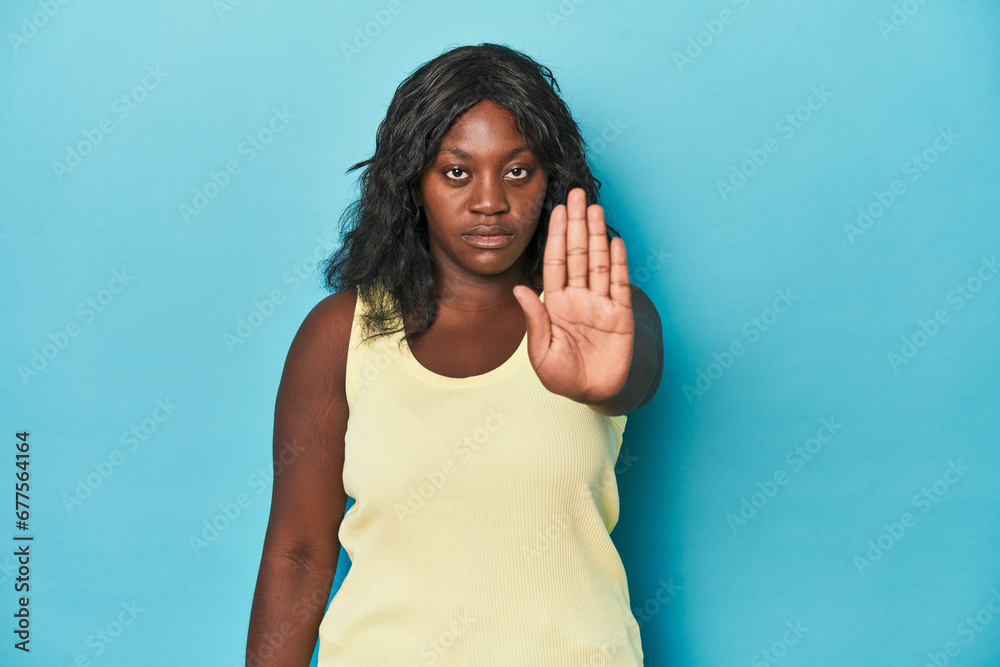 Young african american curvy woman standing with outstretched hand showing stop sign, preventing you. Young african american curvy woman standing with outstretched hand showing stop sign, preventing you.