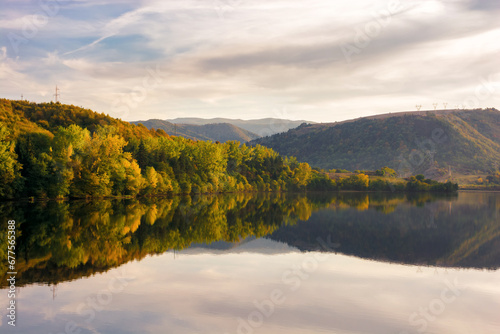 mountainous countryside landscape at sunset. beautiful nature scenery with lake beneath a stunning sky in evening light