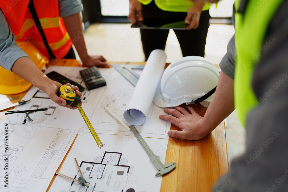 engineers discuss building on blueprint drawing, design building Project in office.