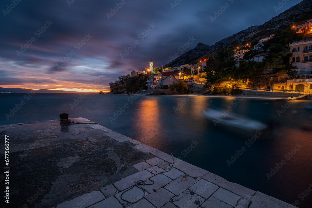 Romantic landscape of a small marina on the Makarska Riviera during a stormy evening - obrazy, fototapety, plakaty 