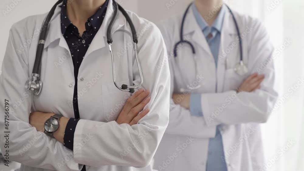 Doctor use the clipboard for making medication notes while another physician works in the background. Medicine concept Doctor use the clipboard for making medication notes while another physician works in the background. Medicine concept