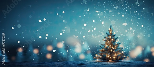 The abstract design on the blue background filled with shimmering lights and a beautiful Christmas tree creates a stunning display of holiday beauty in the night with bokeh and blur adding a