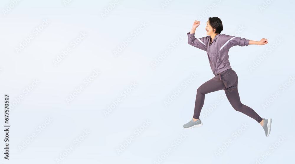ジャンプするスポーツウェアを着た女性　切り抜き全身写真（切り抜き背景透過PNGも販売しております。作成者リンクから「PNG」で検索してください）