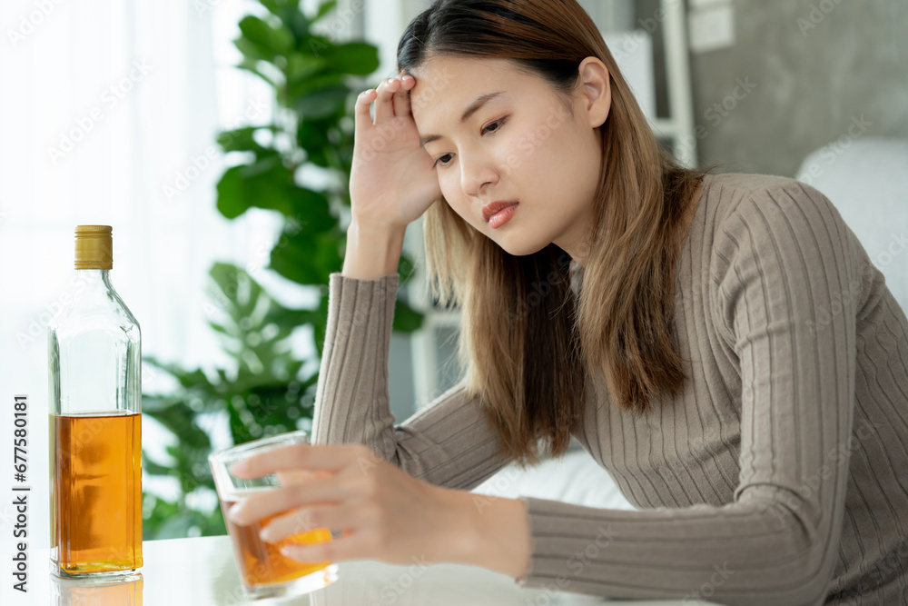 Depressed young Asian woman addicted feeling bad drinking whiskey alone at home, stressed frustrated lonely drinking alcohol suffers from problematic liquor, alcoholism, life and family problems Depressed young Asian woman addicted feeling bad drinking whiskey alone at home, stressed frustrated lonely drinking alcohol suffers from problematic liquor, alcoholism, life and family problems