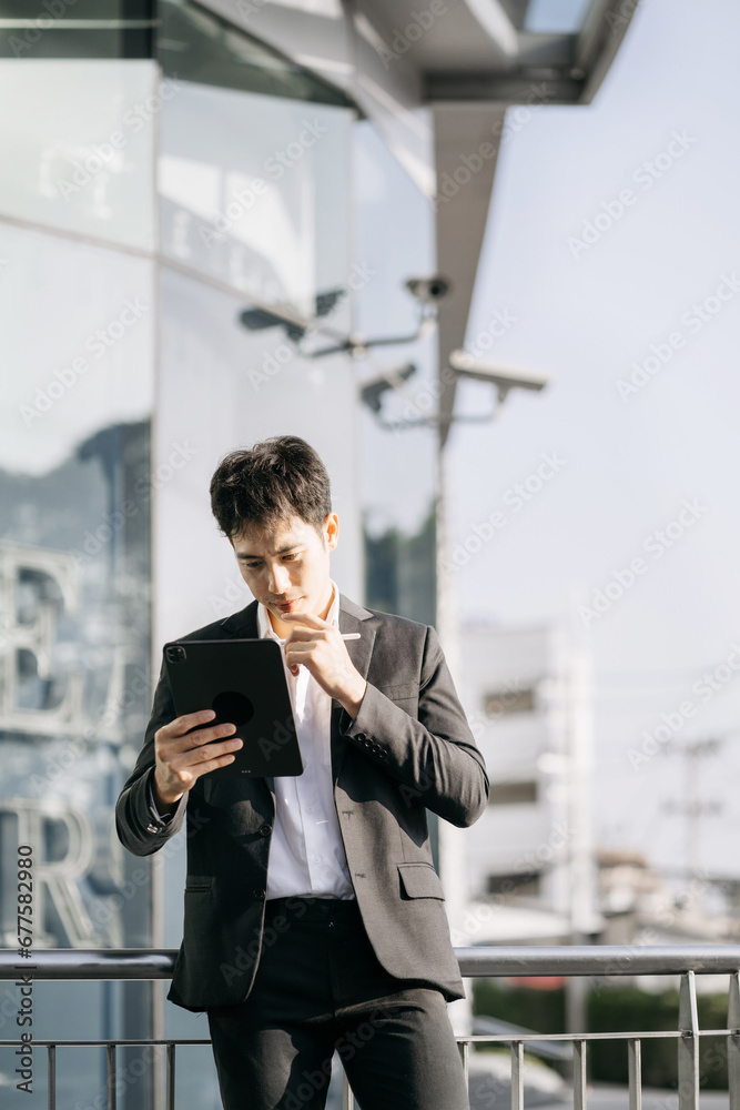Portrait of Asian businessman holding tablet and laptop. Office worker at business center. Portrait of Asian businessman holding tablet and laptop. Office worker at business center.