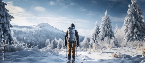 The active man chose to travel during winter to embrace the beauty of nature enjoying the snow covered forest and reaping the health benefits of being in the outdoors which made him happy du
