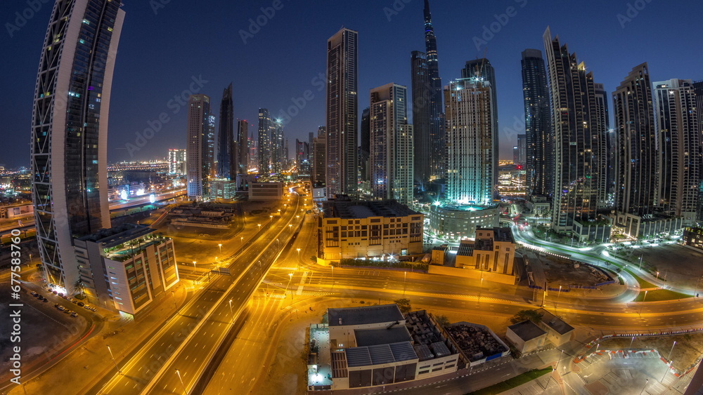 Fototapeta premium Aerial panorama of Dubai Downtown skyline with many towers night to day timelapse.