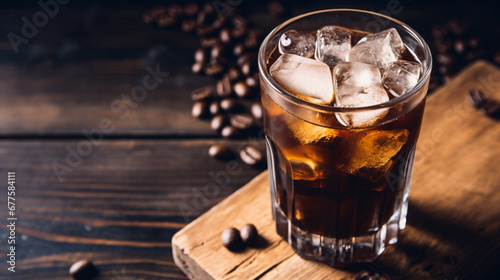 Iced coffee with ice cubes in glass on wooden table photo