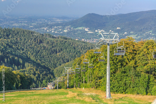 View from the upper station of the chairlift to Mała Czantoria in the Silesian Beskids (Poland) on the Równica hill and the buildings of Ustroń on a sunny summer day. photo