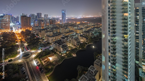 Panorama showing skyscrapers in Barsha Heights district and low rise buildings in Greens district aerial night timelapse. photo