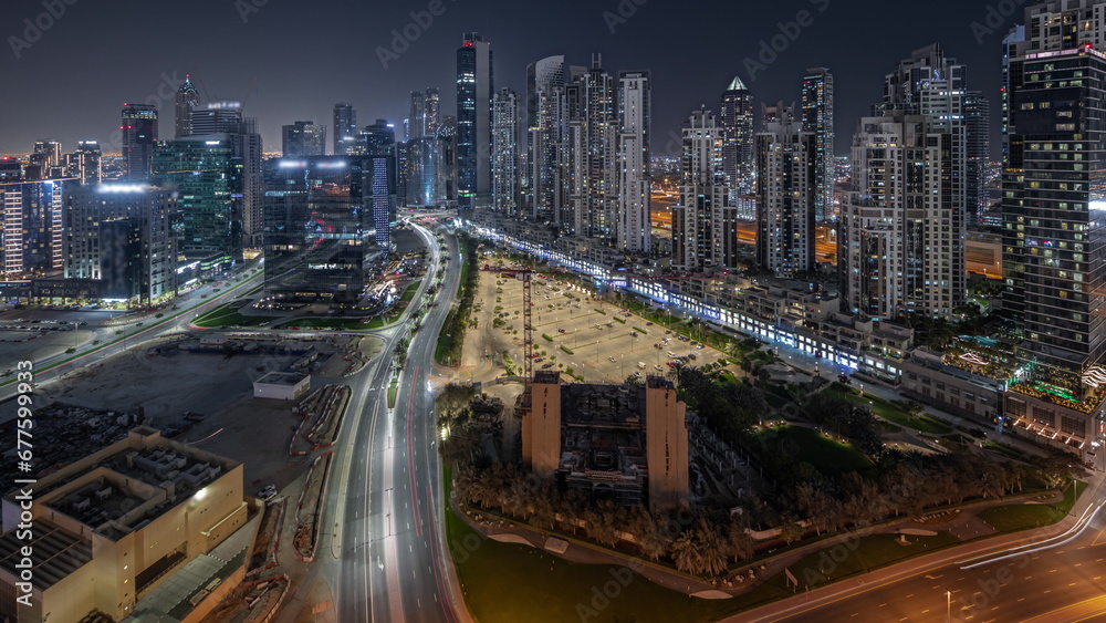 Fototapeta premium Panorama showing Bay Avenue with modern towers residential development in Business Bay aerial night timelapse, Dubai
