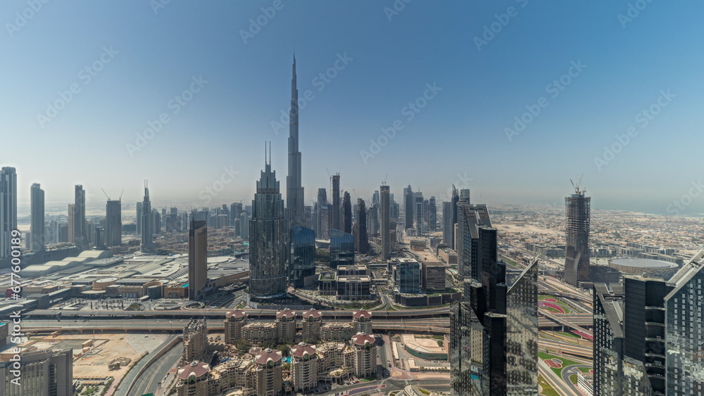 Obraz premium Panorama showing aerial view of tallest towers in Dubai Downtown skyline and highway timelapse.