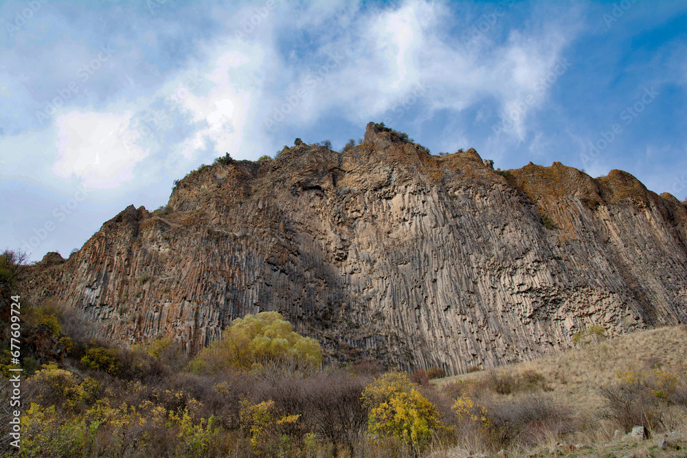 Steep cliffs and golden trees. Autumn landscape and blue sky Steep cliffs and golden trees. Autumn landscape and blue sky