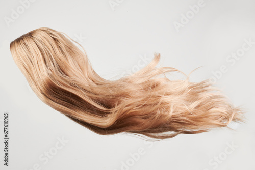 Natural looking shiny hair, fair blonde curls isolated on white background with copy space