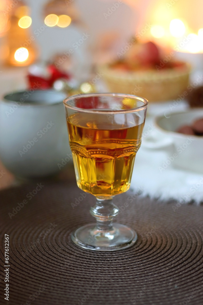 Cup of tea or coffee, glass of wine or juice, bowl of cookies, organic pomegranate, fluffy blanket, pine cones, various Christmas decorations and lit candles on the table. Christmas hygge concept. Cup of tea or coffee, glass of wine or juice, bowl of cookies, organic pomegranate, fluffy blanket, pine cones, various Christmas decorations and lit candles on the table. Christmas hygge concept.