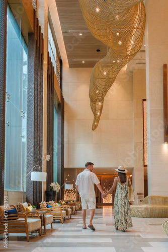 a couple of men and a woman walking in a hotel lobby of a luxury hotel in Thailand photo