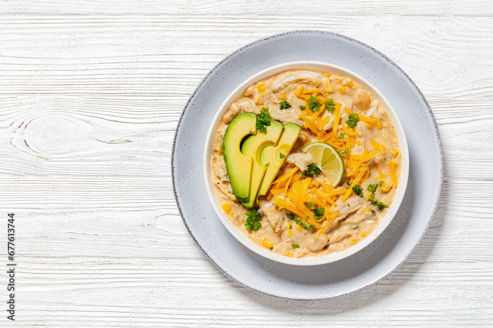 white chicken chili with cheese, avocado in bowl