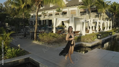 Aerial view of a woman along the swimming pool of luxury resort, Riviere Noire, Le Morne Bramant, Mauritius. photo
