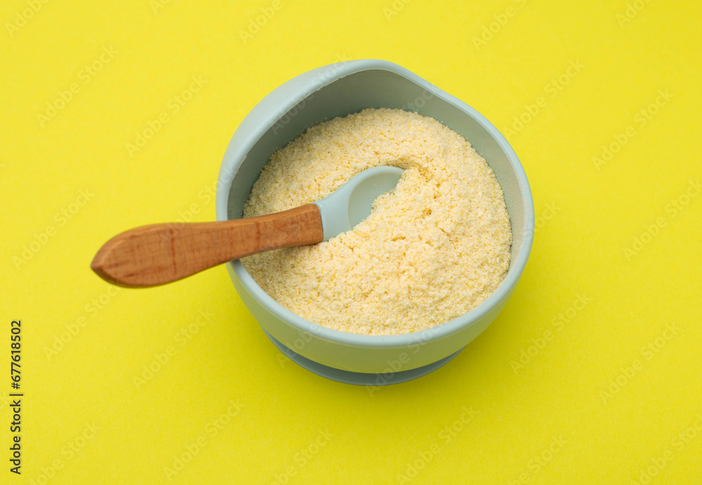 Baby porridge in a plate on a yellow background. Rice porridge for baby's growth and development. Strengthening immunity and health, hypoallergenic Baby porridge in a plate on a yellow background. Rice porridge for baby's growth and development. Strengthening immunity and health, hypoallergenic