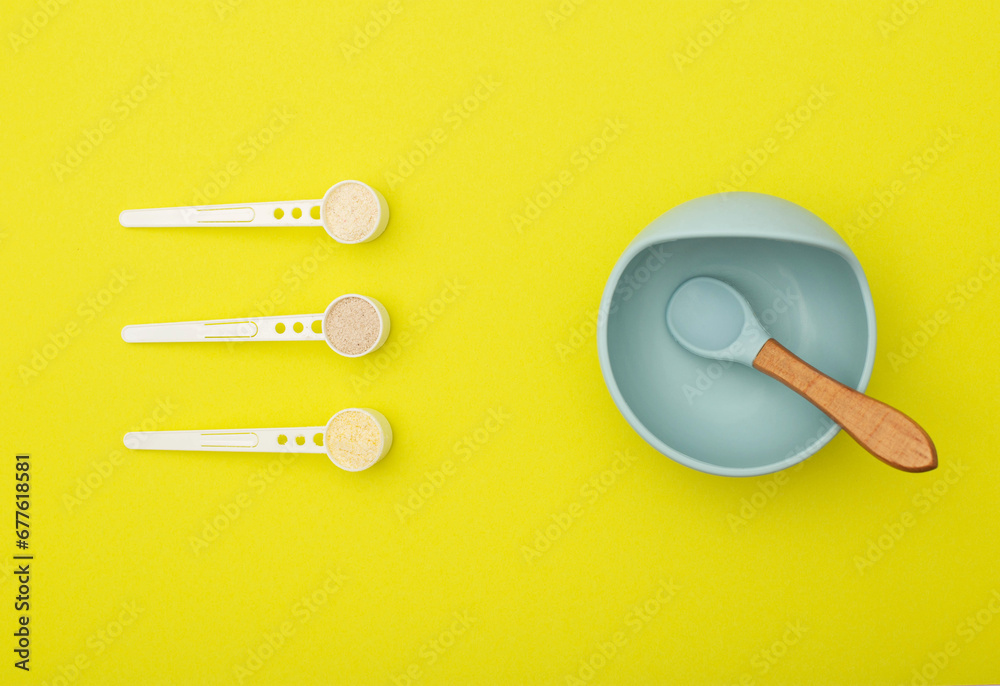 A blue children's plate with a spoon and a set of different dairy-free cereals for children's first feeding. Vitamin-mineral cereals for children, gluten-free, close-up A blue children's plate with a spoon and a set of different dairy-free cereals for children's first feeding. Vitamin-mineral cereals for children, gluten-free, close-up